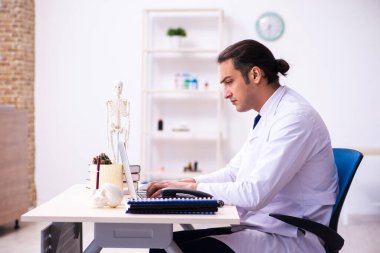 Klinikte çalışan genç erkek doktor.