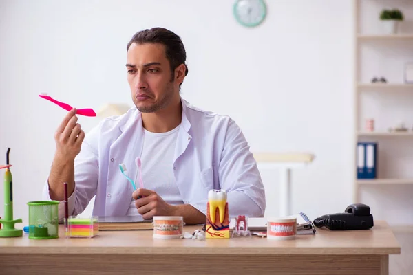 Jovem dentista do sexo masculino que trabalha na clínica — Fotografia de Stock