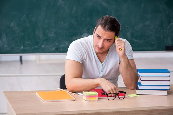 Mladý muž učitel student sedí ve třídě — Stock fotografie