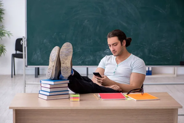 Mladý muž učitel student sedí ve třídě — Stock fotografie