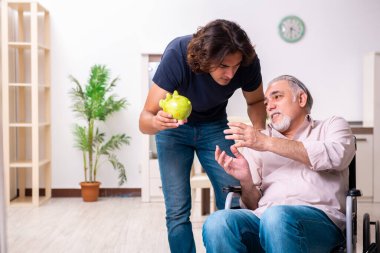 Tekerlekli sandalyedeki yaşlı adam ve genç kötü bakıcı.