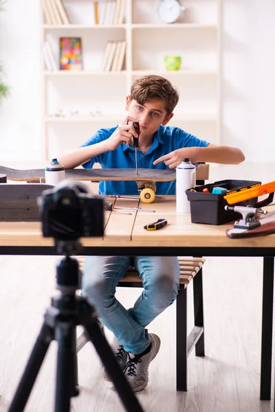 Boy reparación de monopatín y grabación de vídeo para su blog — Foto de Stock