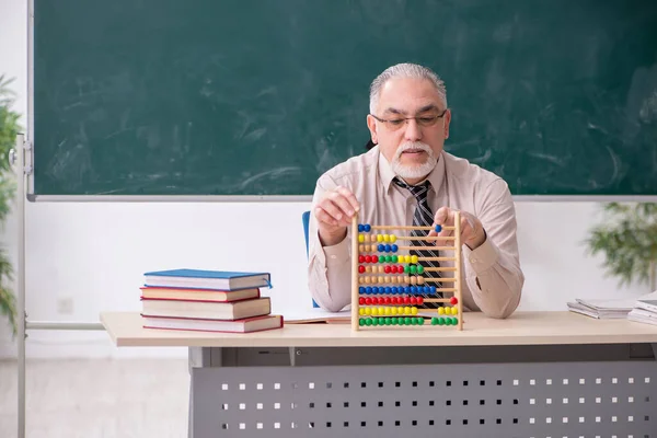 Old male teacher in the classroom