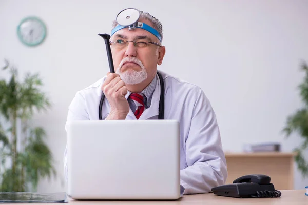 Oude mannelijke arts otoloog werkzaam in de kliniek — Stockfoto