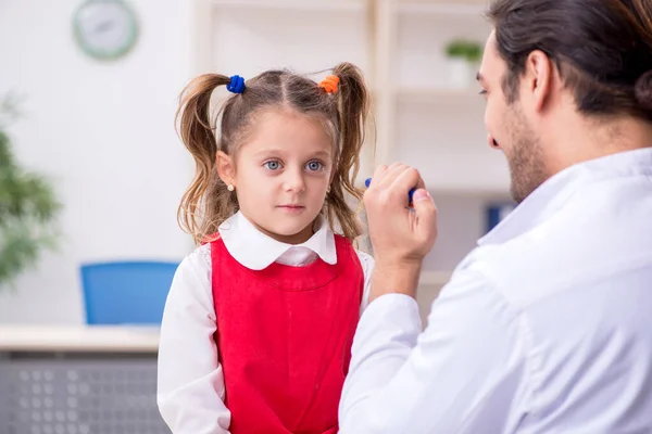 Menina pequena visitando jovem médico oculista masculino — Fotografia de Stock