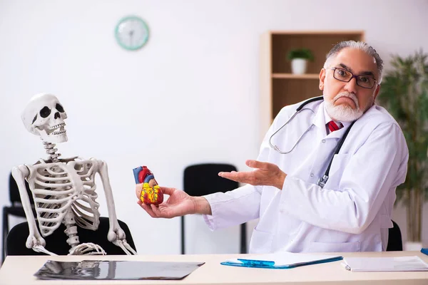 Klinikteki yaşlı erkek kardiyolog ve iskelet hastası. — Stok fotoğraf