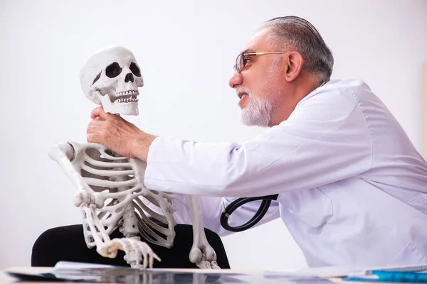 Öreg férfi orvos és csontváz beteg a klinikán — Stock Fotó