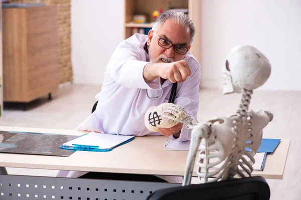 Yaşlı bir erkek doktor kardiyolog ve iskelet hastası. — Stok fotoğraf