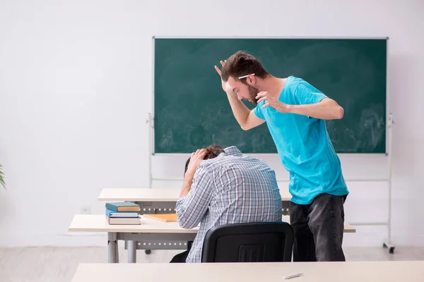 Dois alunos do sexo masculino no conceito de bullying na sala de aula — Fotografia de Stock