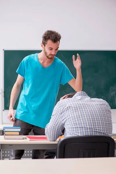 Twee mannelijke leerlingen in het pestconcept in de klas — Stockfoto