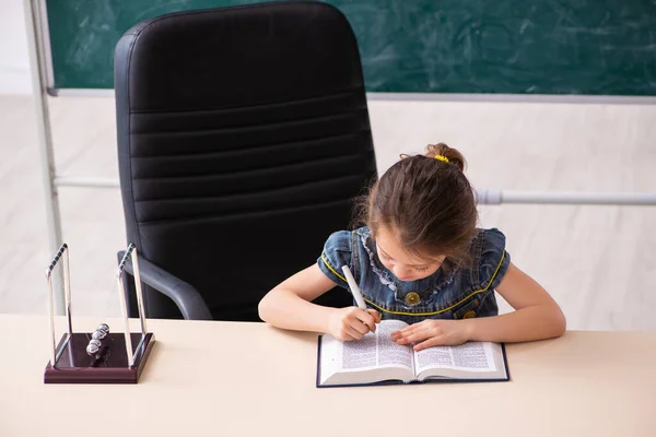 Menina pequena leitura livro na sala de aula — Fotografia de Stock