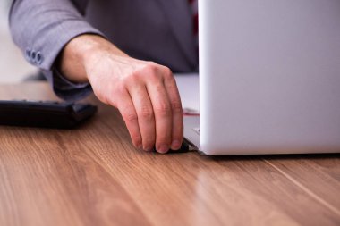 Genç erkek çalışan dizüstü bilgisayara flash bellek yerleştiriyor.