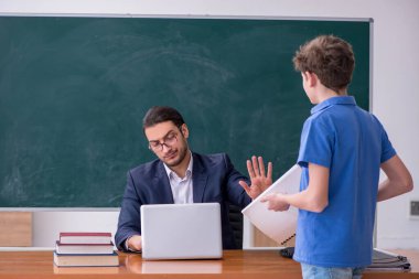 Genç erkek öğretmen ve okul çocuğu sınıfta.