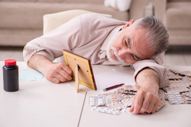 Yaşlı hasta adam evde acı çekiyor.