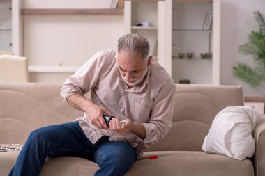 Yaşlı hasta adam evde acı çekiyor.