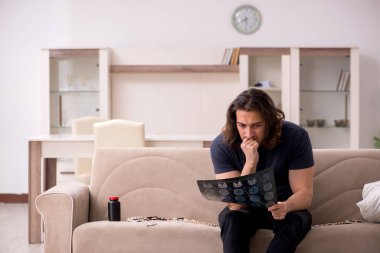 Evde acı çeken genç hasta adam.