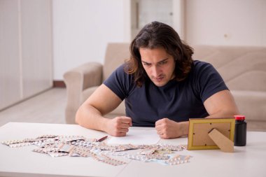 Evde acı çeken genç hasta adam.