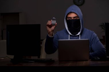 Erkek bilgisayar korsanı, güvenlik duvarını geç saatlerde hackliyor.