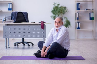 Mola sırasında fiziksel egzersiz yapan yaşlı bir erkek.