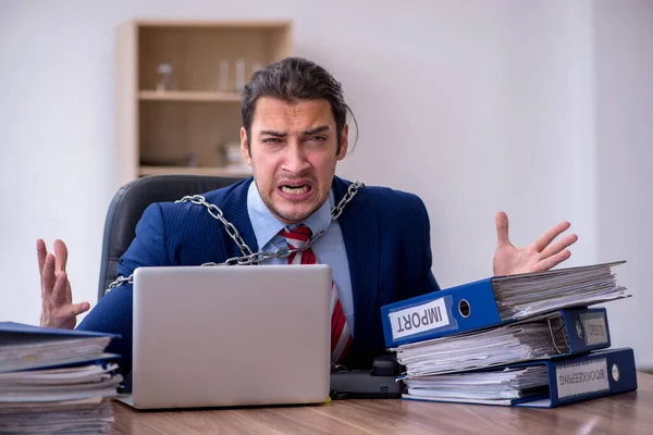 Acorrentado masculino empregado infeliz com excesso de trabalho no escritório — Fotografia de Stock