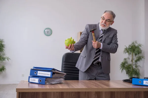 Old male employee holding hammer in budget planning concept — Stock Photo, Image