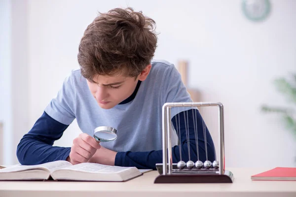 Écolier étudiant la physique à la maison — Photo