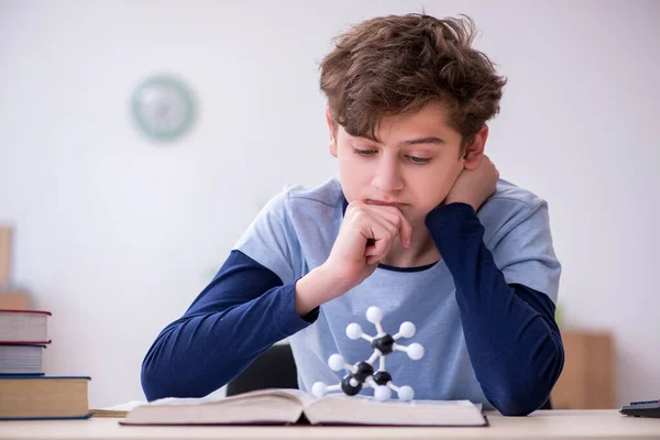 Schooljongen kijkt thuis naar moleculair model — Stockfoto