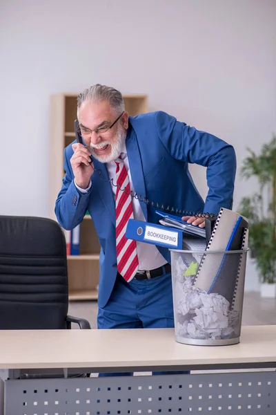 Old businessman employee rejecting new ideas with lots of papers