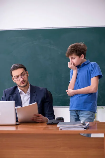 Young male teacher and schoolboy in the classroom — Stock Photo, Image