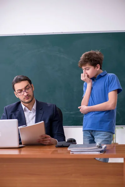 Fiatal férfi tanár és iskolás fiú az osztályteremben — Stock Fotó