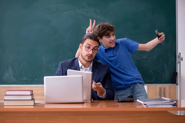 Jovem professor e estudante na sala de aula — Fotografia de Stock