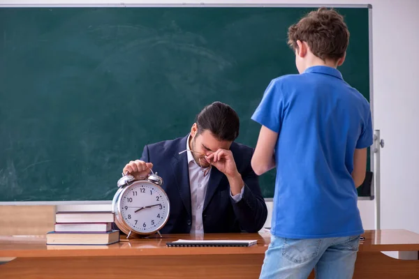 Jonge mannelijke leraar en schooljongen in de klas — Stockfoto