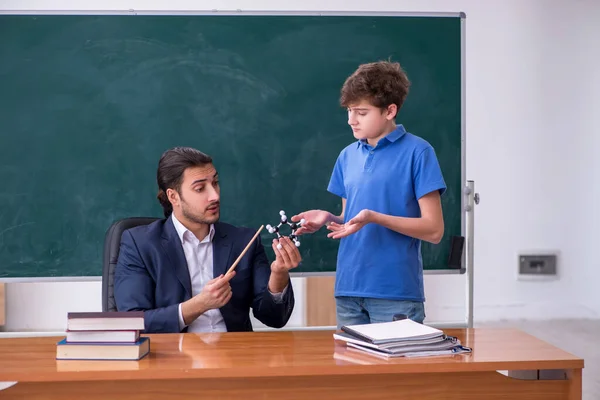 Jonge mannelijke leraar en schooljongen in de klas — Stockfoto