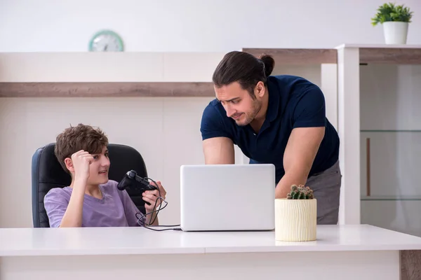 Jovem pai e estudante jogando jogos de computador em casa — Fotografia de Stock