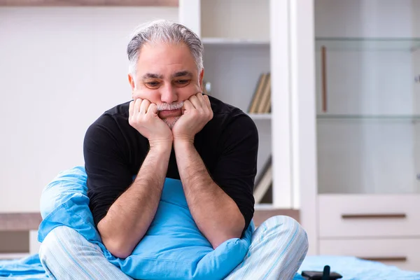 Ongelukkige oude man in de slaapkamer — Stockfoto