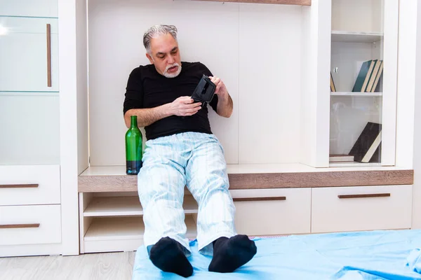 Viejo bebiendo vino en el dormitorio — Foto de Stock