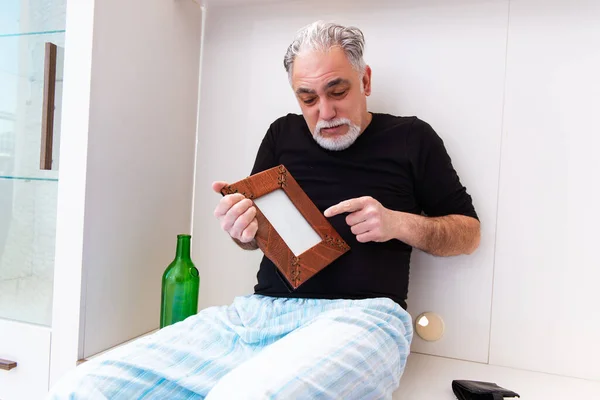 Old man drinking wine in the bedroom — Stock Photo, Image