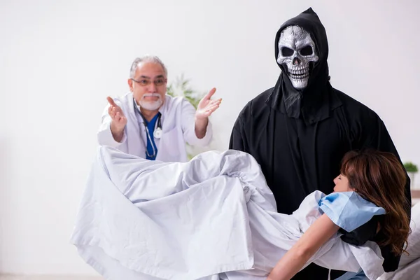 Devil, old doctor and female patient in the clinic — Stock Photo, Image