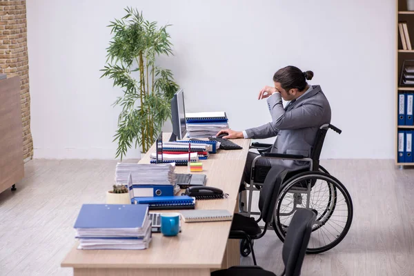 Młody mężczyzna enployee na wózku inwalidzkim w miejscu pracy — Zdjęcie stockowe