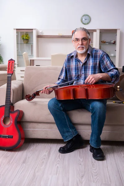 Hombre mayor reparador reparando instrumentos musicales en casa —  Fotos de Stock