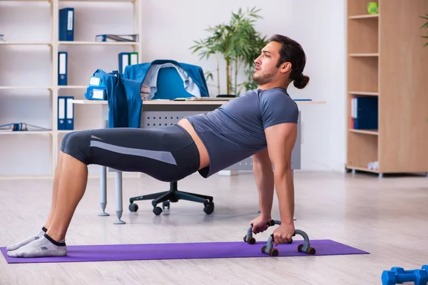 Junge hübsche Angestellte beim Sport im Büro — Stockfoto