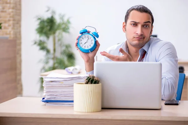 Joven empleado masculino en concepto de gestión del tiempo —  Fotos de Stock