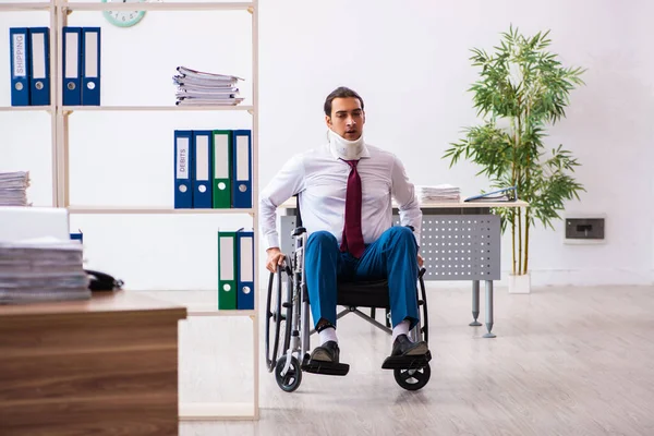 Junge männliche Angestellte im Rollstuhl am Arbeitsplatz am Hals verletzt — Stockfoto