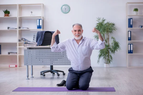 Ältere männliche Mitarbeiter machen in der Pause körperliche Übungen — Stockfoto