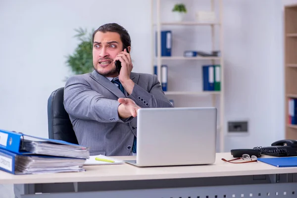 Jeune employé masculin mécontent du travail excessif au bureau — Photo