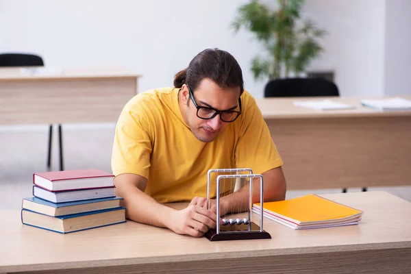 Joven estudiante de física preparándose para los exámenes en el aula — Foto de Stock