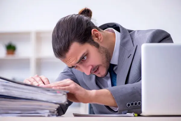 Joven empleado masculino descontento con el trabajo excesivo en la oficina — Foto de Stock