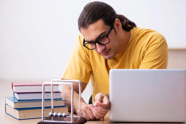 Ung manlig elev fysik förbereder sig för tentor i klassrummet — Stockfoto