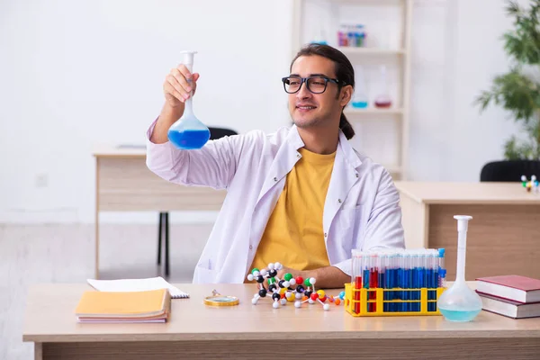 Mladý muž chemik učitel ve třídě — Stock fotografie