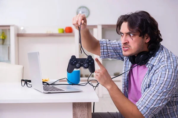 Young male student playing computer games at home — Stock Photo, Image